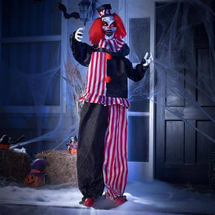 a creepy clown is standing in the dark with his head turned to look