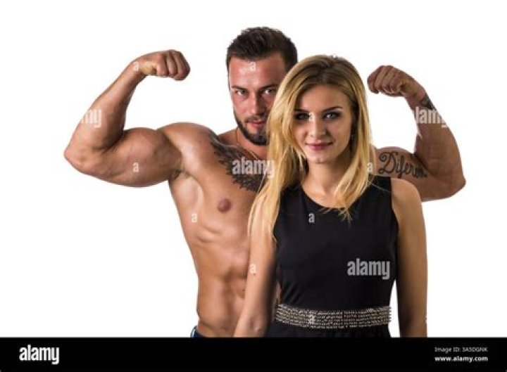 a man and woman posing for a photo in front of a wall with cartoon
